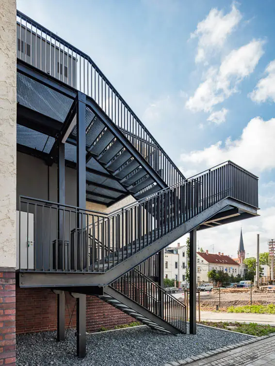 Ein zweiter baulicher Rettungsweg - ausgeführt als Stahltreppe - findet in einer unauffälligen Gebäudenische Platz Ein zweiter baulicher Rettungsweg - ausgeführt als Stahltreppe - findet in einer unauffälligen Gebäudenische Platz