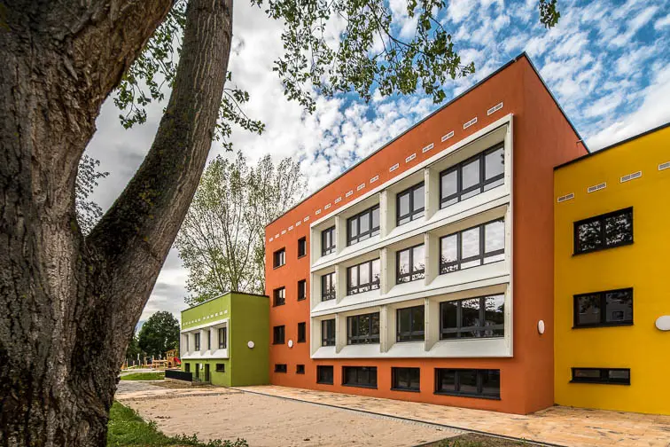 Die Kita &raquo;Entdeckerparadies&laquo; besteht aus drei gestaffelten, gegeneinander versetzten und bunten Bauk&ouml;rpern