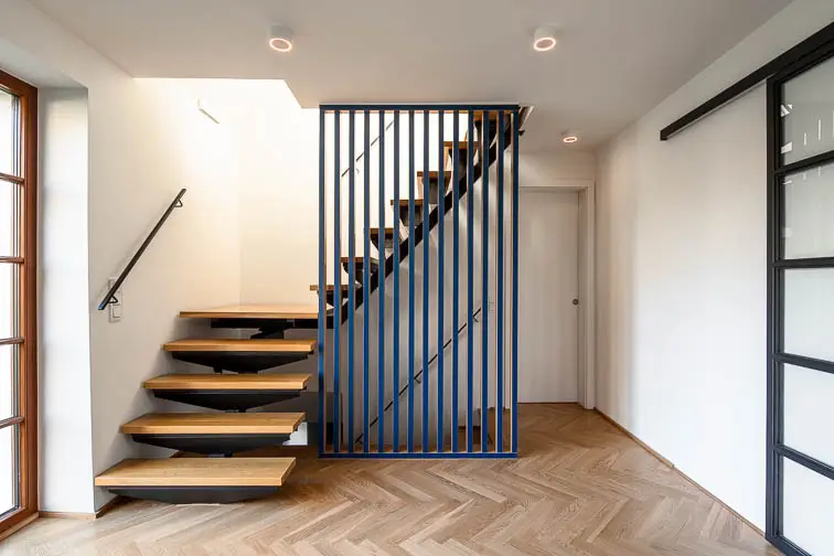 Innentreppe mit Stahlholm und Harfengeländer aus Holz